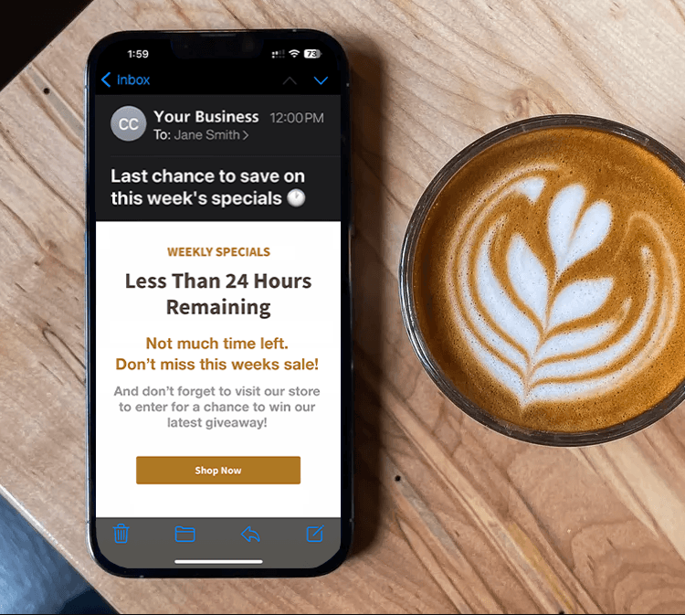An iPhone on a wood table next to a latte.